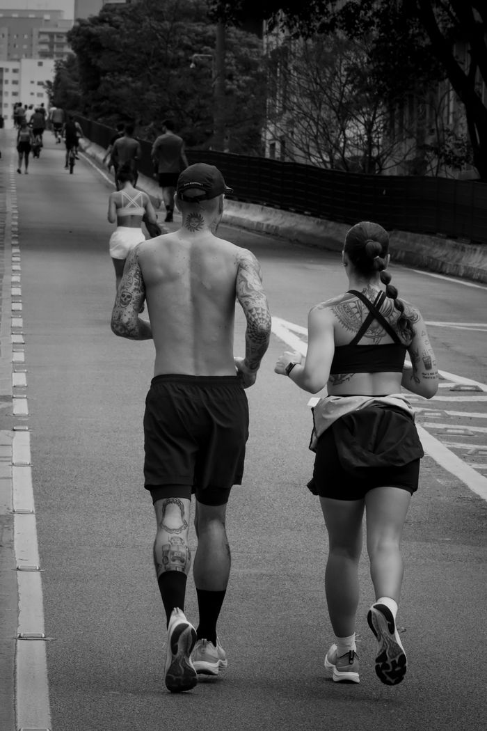 Crafting Captivating Headlines: Your awesome post title goes here A tattooed couple jogging together in a city street, promoting fitness and healthy lifestyle.