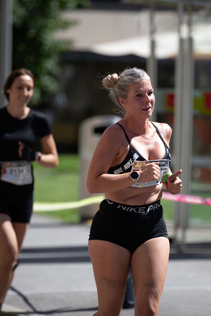 Mastering the First Impression: Your intriguing post title goes here Woman running in a city marathon, demonstrating fitness and endurance.
